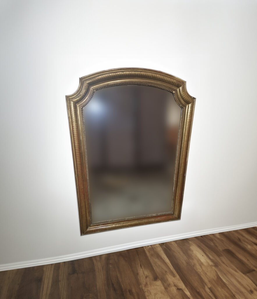 A Louis Philippe gilded mirror hanging on a white wall